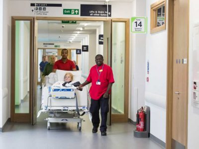 A patient being moved in her bed in a hospital