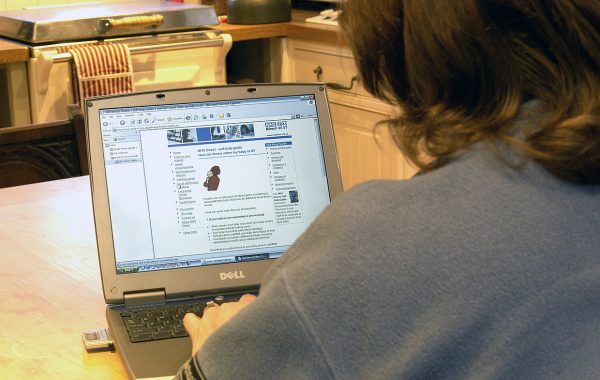 A woman using her laptop to look at NHS Direct website