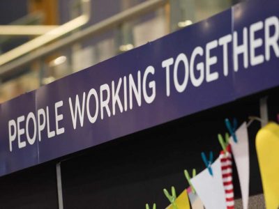 Sign at an event saying 'people working together'