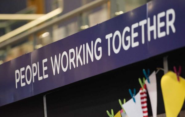 Sign at an event saying 'people working together'