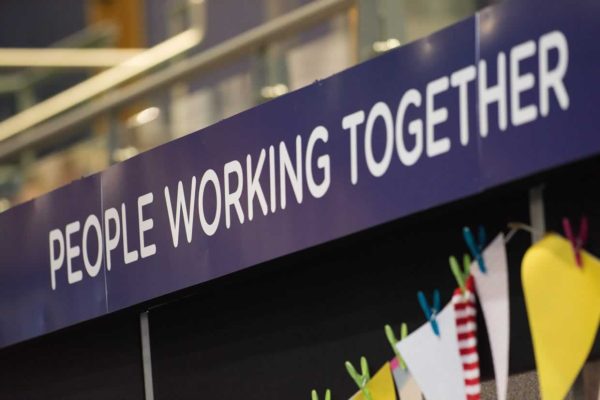 Sign at an event saying 'people working together'