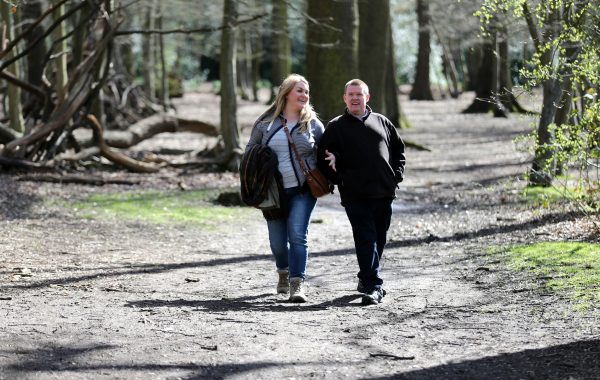 A couple walking in a wood. Image credit: World Obesity Federation