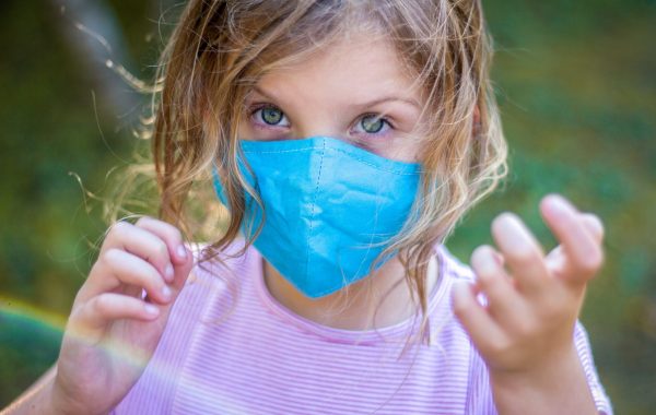 A little girl wearing a facemask