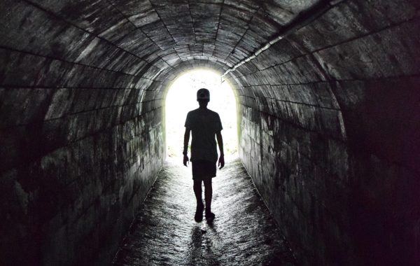 A person walks towards the light at the end of the tunnel