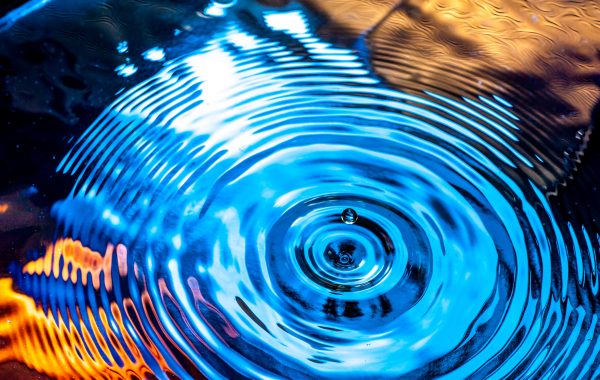 A water drop and ripples on the water's surface