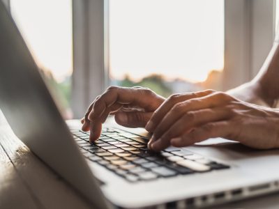 A person's hands using a laptop