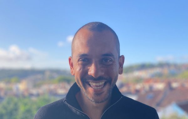 Roy is facing the camera and smiling with Bristol in the background