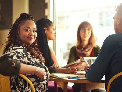 A woman in a meeting smiles at the camera