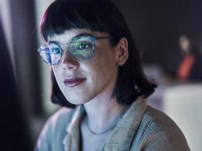 A female researcher is facing the camera as she reviews data on her computer