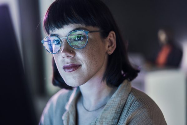 A female researcher is facing the camera as she reviews data on her computer