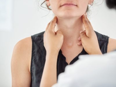 A doctor is checking a patient's neck