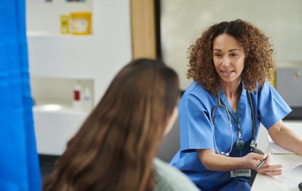 A healthcare professional talks to a female patient