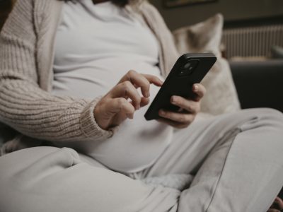 A pregnant woman uses a mobile phone