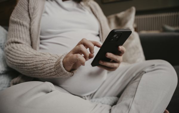 A pregnant woman uses a mobile phone